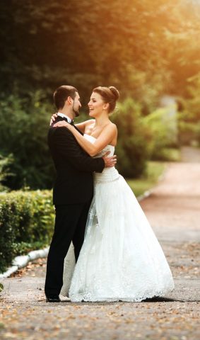 Beautiful wedding couple in each other's arms in the park